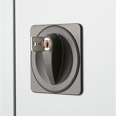 Close-up of a gray door lock with a key. The lock is set into a square plate.