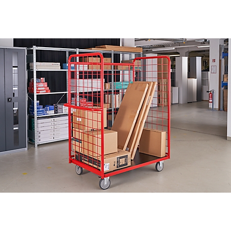 Red transport cart loaded with goods in a warehouse.