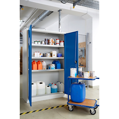 Ein offener blauer Schrank mit verschiedenen Behältern und Farbdosen. Daneben ein Rollwagen mit Farbeimern und einem blauen Fass.