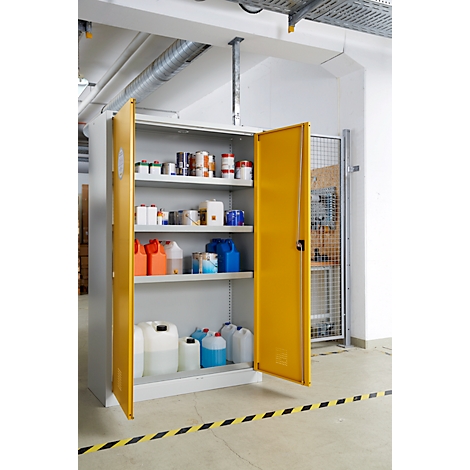 Offener gelber Schrank mit Chemikalien und Behältern, Warnmarkierung am Boden.