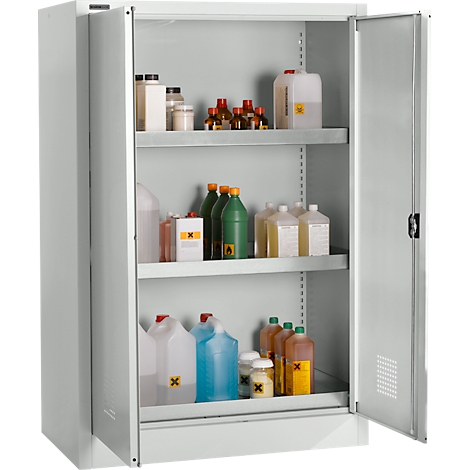 Ein Stahlschrank mit offenen Türen. Auf Regalen sind verschiedenfarbige Kanister, Flaschen und Gläser mit Gefahrgutzeichen zu sehen.