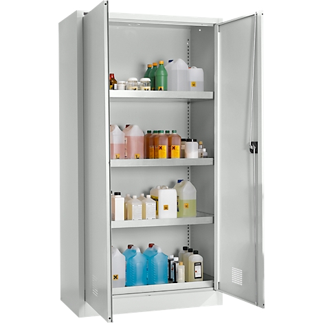 Offener Stahlschrank mit Chemikalienflaschen. Gelbe Warnsymbole, farbige Flüssigkeiten, viele verschiedene Behälter.