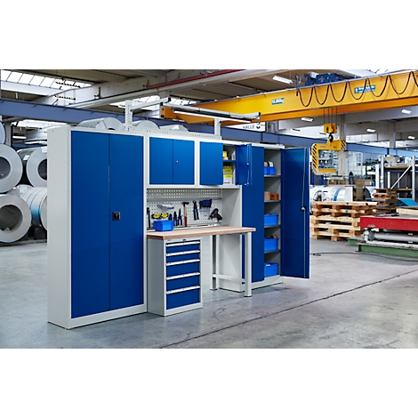 Workbench and cabinet wall in a workshop. Tools, cabinets and drawers in blue and beige.