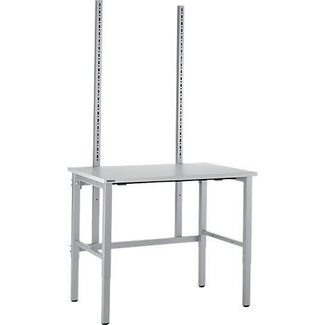 Gray work table with two vertical columns with numerous holes. Metal legs, rectangular table top.
