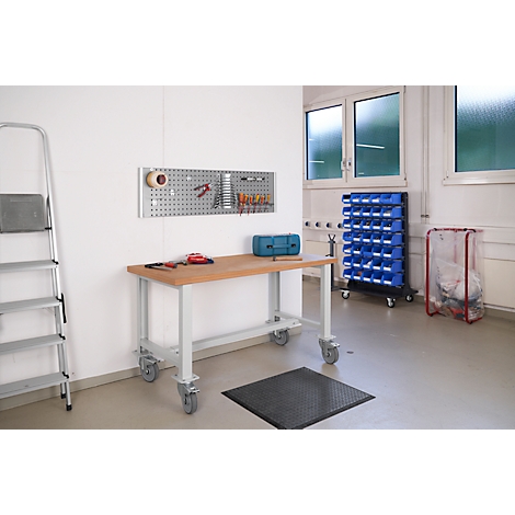 Workshop with workbench, pegboard, toolbox, and blue bins. A stepladder stands on the left.