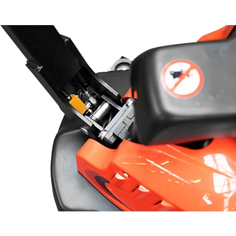Detailed view of the mechanics of a lawnmower, with orange and black components. In the background a no-horn sign.