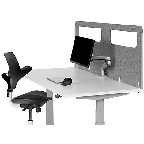 Bürotisch mit Monitor, Tastatur, Maus und Stuhl. Im Hintergrund graue Trennwand. Alles in neutralen Farben.