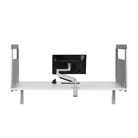 Ein Arbeitsplatz mit weißem Tisch, Monitor, grauem Trennelement. Der Monitor ist an einem Arm befestigt.