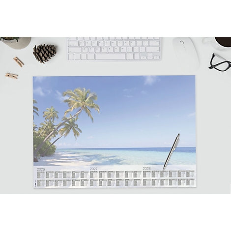 Kalender mit Strandmotiv auf Schreibtisch. Ein Stift liegt auf dem Kalender.