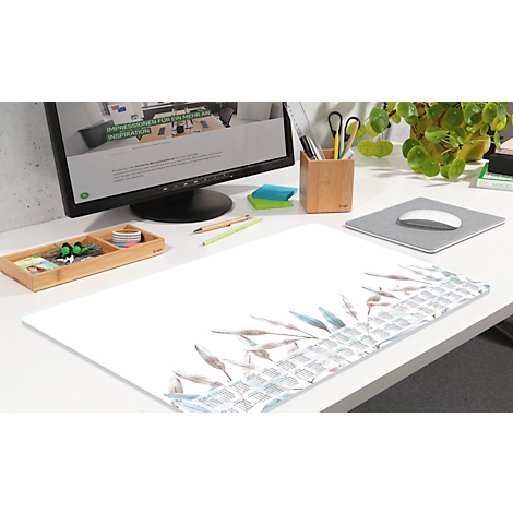 Schreibtisch mit Monitro, Mauspad mit Pflanzen-Design. Im Hintergrund Stiftehalter, Grünpflanze und Büroaccessoires.
