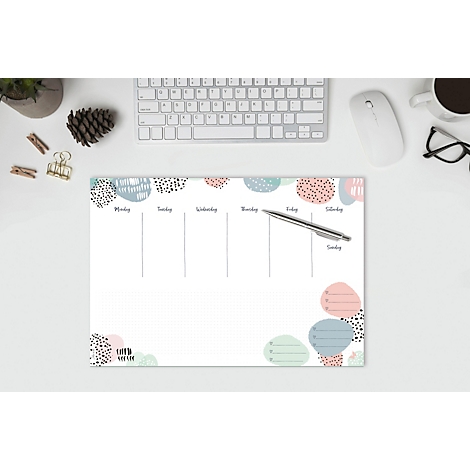 Wochenplaner mit abstrakten bunten Formen, Stift, Tastatur und Maus auf weissem Schreibtisch.