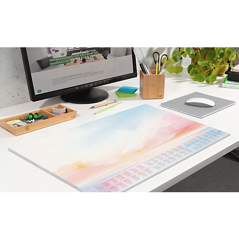Schreibtisch mit bunten Unterlage, Tastatur-Design. Auf dem Tisch: Monitor, Stifte, Mauspad, Pflanzen. Helle, freundliche Atmosphäre.