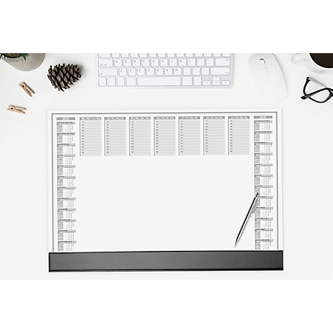 Ansicht von oben auf einem Schreibtisch. Ein Kalenderblock mit grauen Feldern und einer silbernen Kugelschreiber liegt auf dem Tisch. Daneben: Tastatur, Maus, Brille.