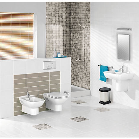Salle de bain lumineuse avec toilettes, bidet, lavabo et douche. Tons blancs, beiges et marrons.