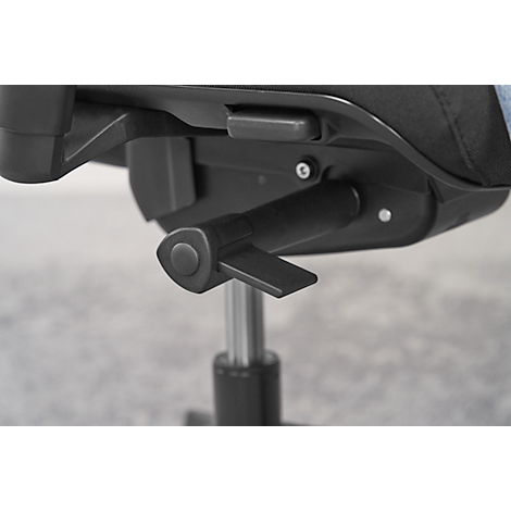 Close-up of a black chair mechanism with lever, dial and metal bar, against a gray background.