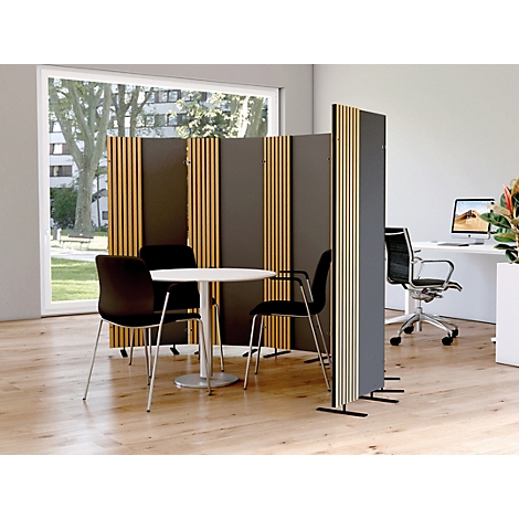 Bureau avec un séparateur de pièce et une table avec des chaises. En arrière-plan, un bureau avec un écran.