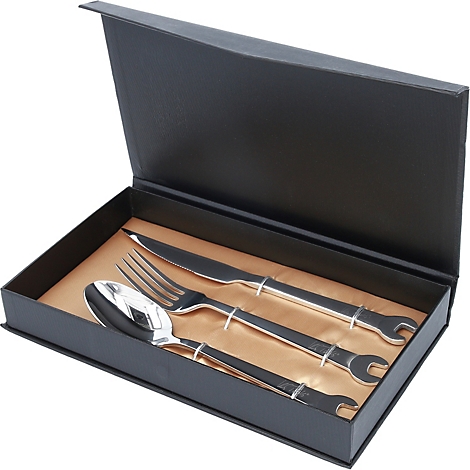 Service à couverts avec design de clé à molette dans une boîte noire, sur fond doré.