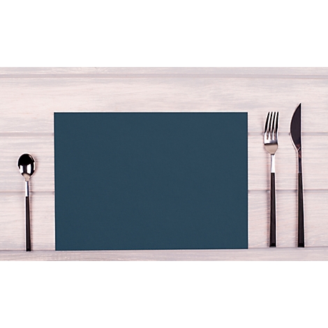Nappe de table bleu foncé avec couverts sur une surface en bois. Une cuillère à gauche, une fourchette et un couteau à droite.
