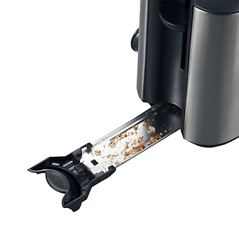 Close-up of a toaster with the crumb tray open and full of crumbs. The toaster is stainless steel and black.