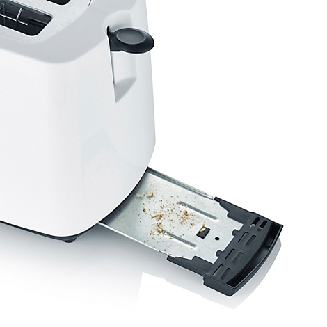 Close-up of a white toaster, the crumb tray is open and filled with crumbs.