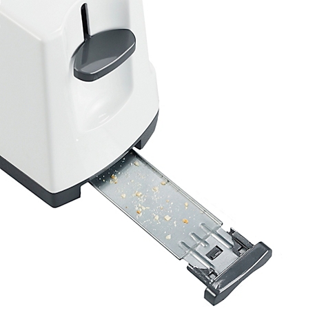 Nahaufnahme eines weissen Toasters mit geöffneter Krümelschublade; Krümel liegen darin. Die Schublade ist aus Metall.