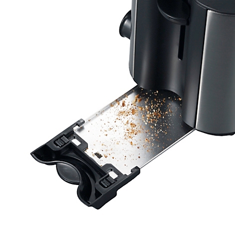 Nahaufnahme eines Toasters mit herausgezogener Krümelschublade. Die Schublade ist mit Brotkrümeln bedeckt.