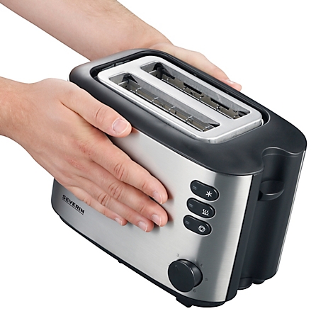 Ein Mann hält einen silbernen Toaster mit schwarzem Rahmen und Knöpfen.