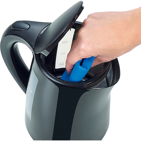 Une main nettoie l'intérieur d'une bouilloire noire avec un chiffon bleu, couvercle ouvert.