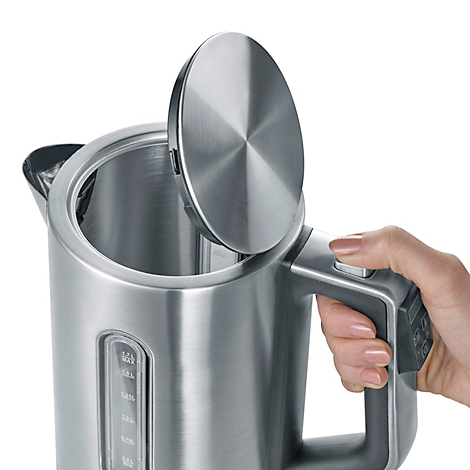 Close-up of a stainless steel kettle with the lid open, hand pressing a button.