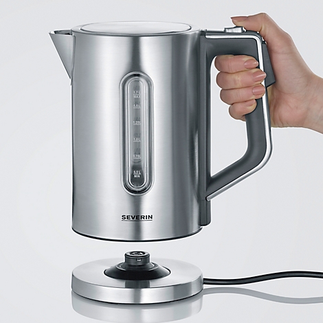 A silver kettle floats above its base, held by a hand. A black handle and a viewing window can be seen.