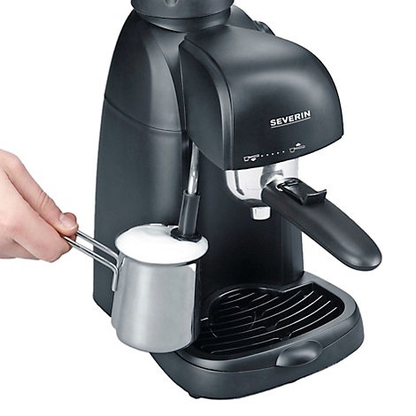 Schwarze Espressomaschine von Severin, mit Milchschaum zubereitend. Eine Hand hält einen kleinen Edelstahl-Milchkännchen.