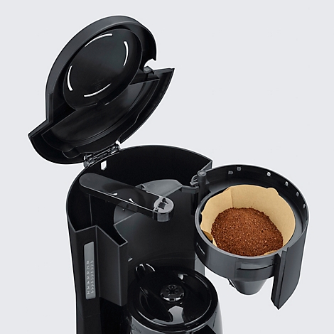 Nahaufnahme einer schwarzen Kaffeemaschine mit geöffnetem Deckel. Der Filterhalter mit Kaffeepulver ist zu sehen.