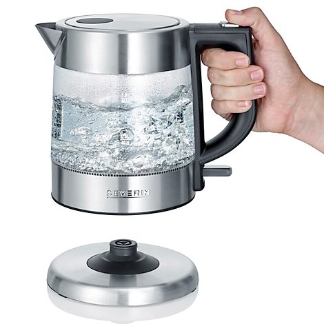 Ein elektrischer Wasserkocher aus Edelstahl und Glas, gefüllt mit kochendem Wasser, wird an einem Griff gehalten.
