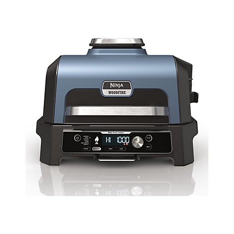 Blauer Ninja Woodfire Elektrogrill mit Bedienfeld, digitaler Anzeige und silbernem Griff vor weißem Hintergrund.