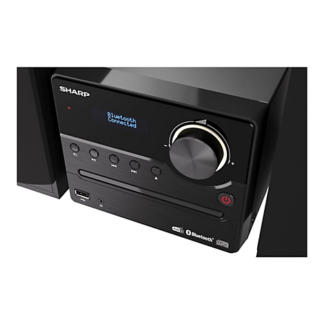 Nahaufnahme der schwarzen Sharp Musikanlage mit beleuchtetem Display, Lautstärkeregler und CD-Laufwerk.