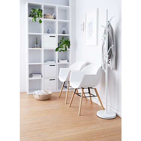 Two white chairs in front of a white wall. Behind them is a shelf, a coat rack, and a wooden floor.