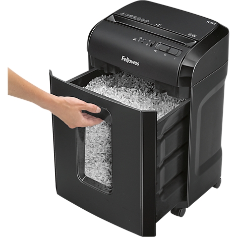 A black paper shredder with its drawer being opened, showing the shredded paper. A hand is holding the handle.