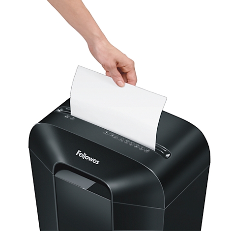 A hand feeds a white sheet of paper into a black Fellowes paper shredder.