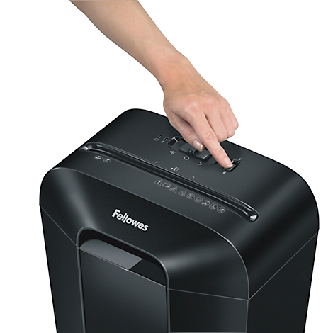 Person presses a button on a paper shredder. Black shredder with white Fellowes lettering.