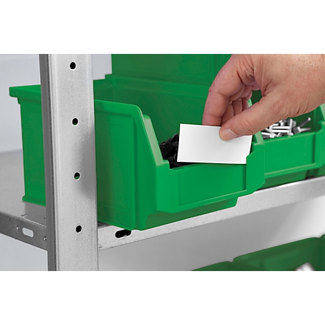 Eine Hand steckt ein leeres weißes Etikett in eine grüne Sichtlagerbox in einem Metallregal.