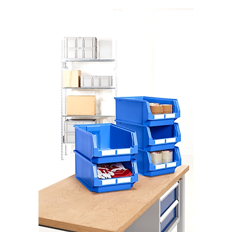 Blaue Lagerboxen auf einem Tisch mit roter Kleidung und braunen Paketen.