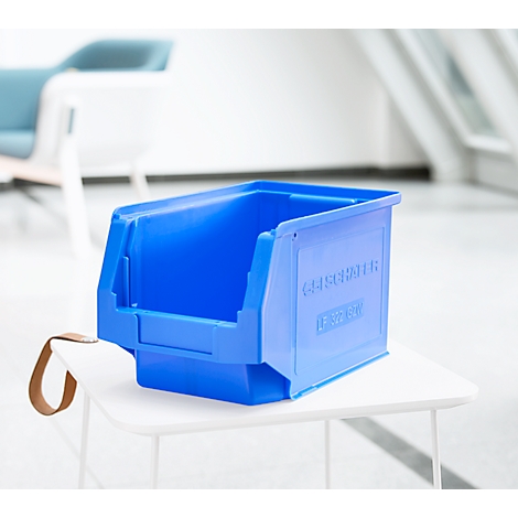 Blaue Sichtlagerbox aus Kunststoff mit offenem Vorderteil steht auf einem weißen Stuhl.