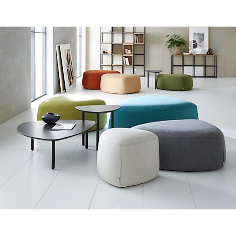 A bright room with colorful ottomans, coffee tables, and a shelf. Various colors: green, blue, orange, beige, gray, and white.