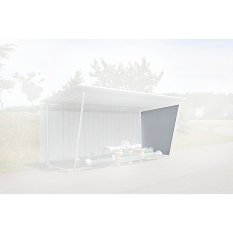 A gray outdoor shelter. It has a metal frame and a gray roof. Stacks of wood are underneath. Trees in the background.