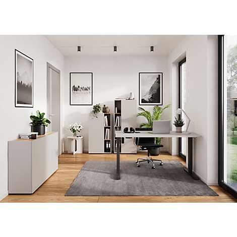 Un bureau à domicile moderne avec un bureau, un ordinateur portable, une chaise de bureau, des plantes, des photos et un tapis gris.