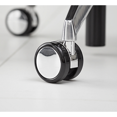 Gros plan de deux roulettes de chaise, couleur chrome, pneu noir, sur un sol clair.