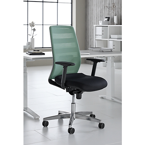 Chaise de bureau avec dossier en maille verte et assise noire, devant un bureau blanc. Fenêtre en arrière-plan.