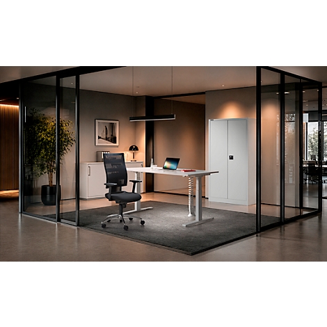 Bureau moderne avec bureau, chaise pivotante noire et armoire blanche dans une salle de conférence vitrée.