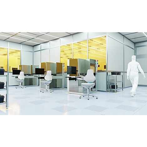 Intérieur d'une salle blanche avec des postes de travail et une personne en combinaison blanche. Fenêtres jaunes, environnement stérile.