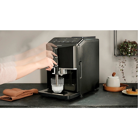 Kaffeemaschine in Aktion: Hände bedienen Gerät, Milch in Glas. Ambiente: Küche.